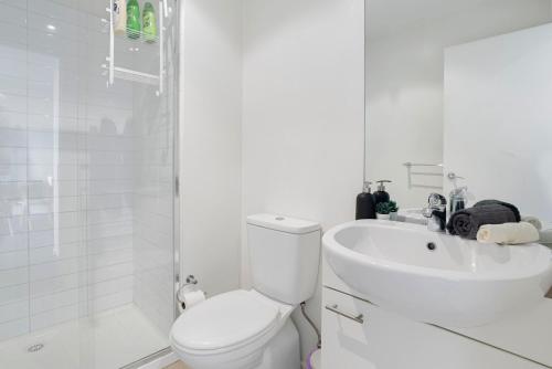 een witte badkamer met een toilet en een wastafel bij A Comfy & Cozy 2BR Apt Near Flemington Races in Melbourne