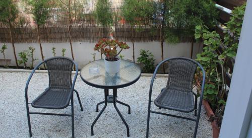twee stoelen en een glazen tafel met een beker erop bij Estia Luxury Maisonette in Paphos City