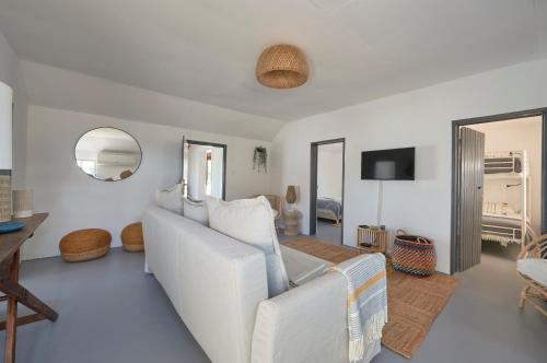 a living room with a white couch and a mirror at Comporta Sandy Villa, By TimeCooler in Comporta