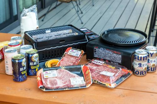 a table topped with meat and cans of soda at 貸温泉別荘Clover天城杉のログハウス伊豆高原 in Ito
