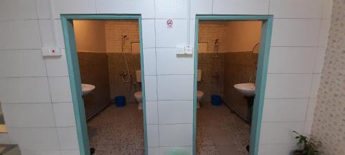 a bathroom with three sinks and two open doors at Wind Valley Farmstay in Kundasang