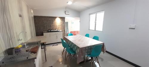 a kitchen with a table and chairs in a room at Wind Valley Farmstay in Kundasang