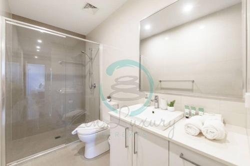 y baño con aseo, lavabo y ducha. en ZEN At ARRAY: 2BR Retreat in CBD en Darwin