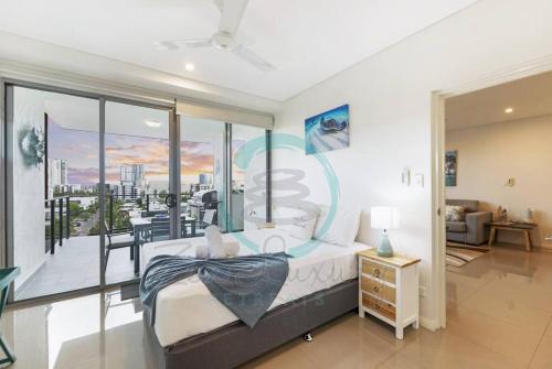 een slaapkamer met een bed en een groot raam bij ZEN At ARRAY: 2BR Retreat in CBD in Darwin