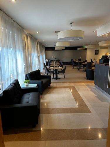 a lobby with couches and tables in a restaurant at Bairnsdale International in Bairnsdale
