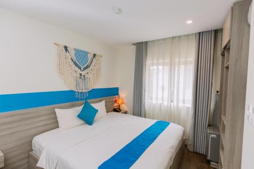 a bedroom with a large bed with a blue headboard at TÒ VÒ Hostel 2 - Huế in Hue