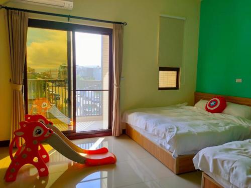 1 dormitorio con 2 camas y ventana con balcón en 童趣漫旅溜滑梯民宿 可預約包棟, en Taitung