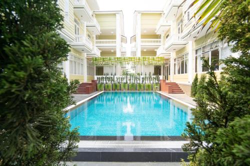 a swimming pool in the middle of a building with trees at Hawal Boutique Villa Hoi An in Hoi An