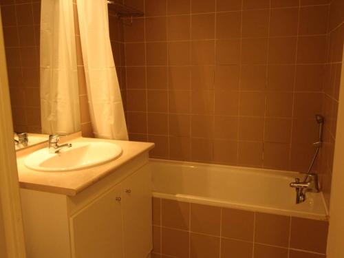 a bathroom with a sink and a bath tub at Appartement Bagnères-de-Luchon, 2 pièces, 4 personnes - FR-1-313-222 in Luchon