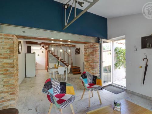 - un salon avec des chaises et une salle à manger dans l'établissement Gîte confort à Balbigny : 2 chambres, terrasse, jeux, équipements modernes, charges incluses - FR-1-496-282, à Balbigny