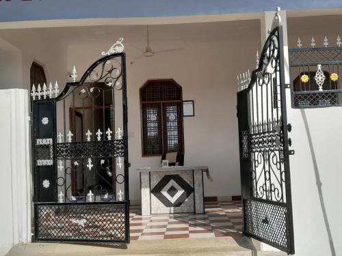 an entrance to a house with a black gate at Rani Palace in Khajurāho