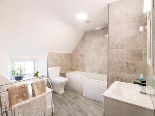a bathroom with a tub and a toilet and a sink at Manor View in Oakham