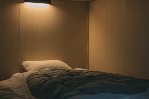 een slaapkamer met een bed met een lamp aan de muur bij 天草VIVID V2 in Kami Amakusa