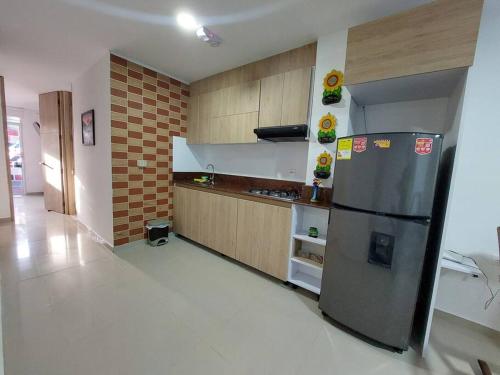 a kitchen with a stainless steel refrigerator in a room at Hermoso Apartamento Cerca a la Playa Puerto Colombia in Puerto Colombia