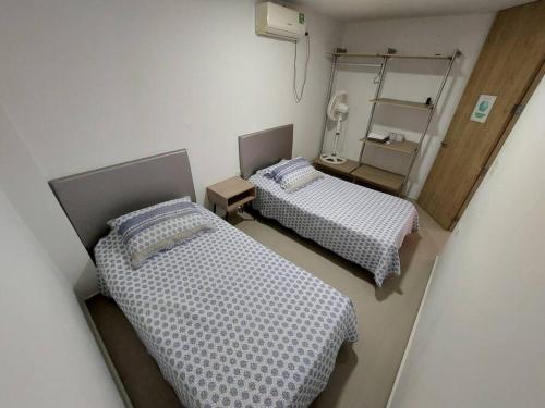 2 camas en una habitación pequeña con espejo en Hermoso Apartamento Cerca a la Playa Puerto Colombia, en Puerto Colombia