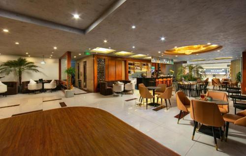a lobby with a restaurant with tables and chairs at Hanoi 20 Hotel HN - by BAY LUXURY in Hanoi