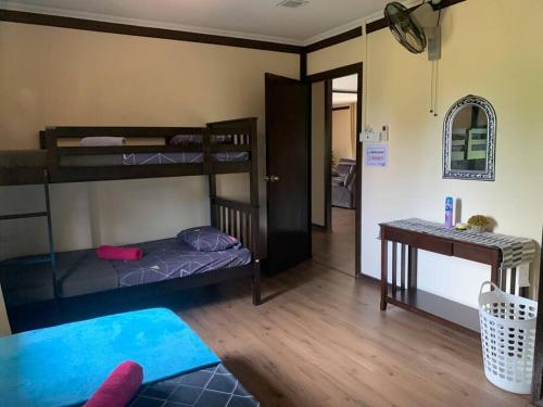 a room with two bunk beds and a table at Teratak Bayu STC in Kuala Terengganu