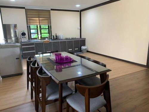 a kitchen with a table and chairs in a room at Teratak Bayu STC in Kuala Terengganu