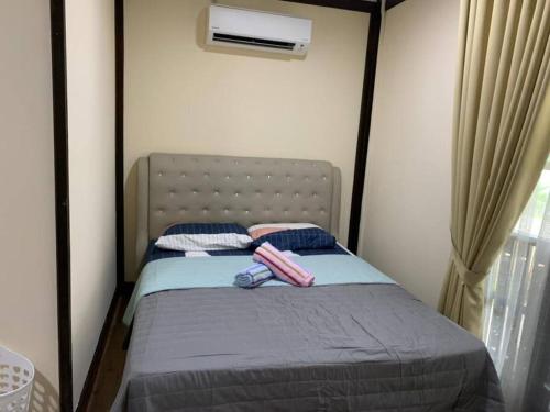 a bed with two pillows on it in a bedroom at Teratak Bayu STC in Kuala Terengganu