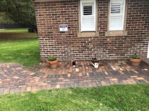 a brick house with two potted plants in front of it at The Stables in Armidale