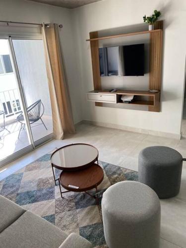 a living room with a tv and a table and chairs at Acogedor dpto! Zona Conmebol 505 in La Mercedes