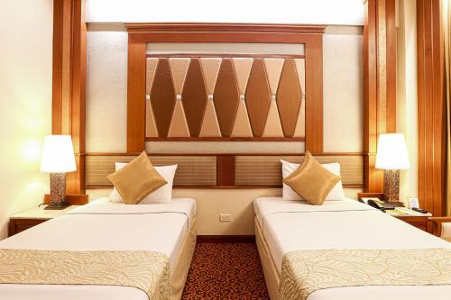 فندق إيجا بانكوك في بانكوك: سريرين في غرفة الفندق مع مصباحين