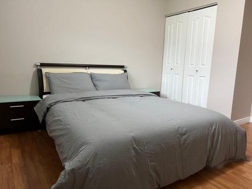 1 cama en un dormitorio con una pared blanca en Independent access, one bedroom, one living room, one kitchen and one bathroom en Richmond