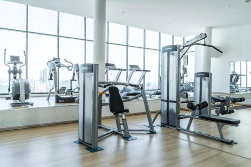 a gym with cardio equipment in a large room with windows at One Room Studio with WiFi and MRT in Seri Kembangan