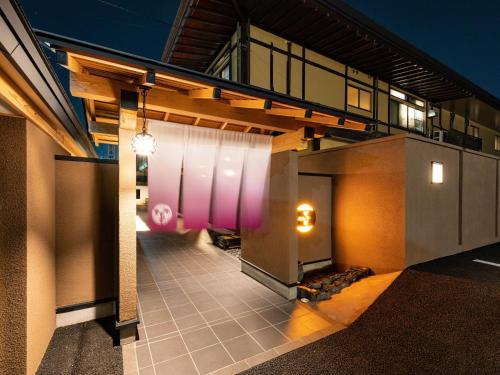 a view of a building with a pink wall at Meitei no Yado Hotel Koshien in Fuefuki