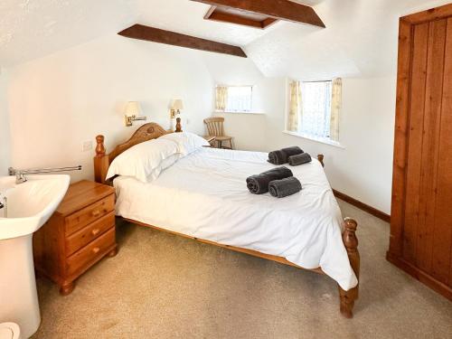 a bedroom with a large bed and a sink at Swallows in Delabole