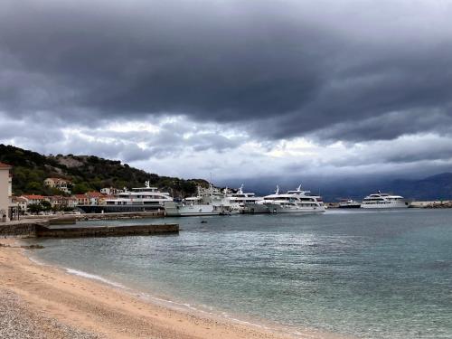 a group of boats docked in the water near a beach at Studio "MOL" in Baška