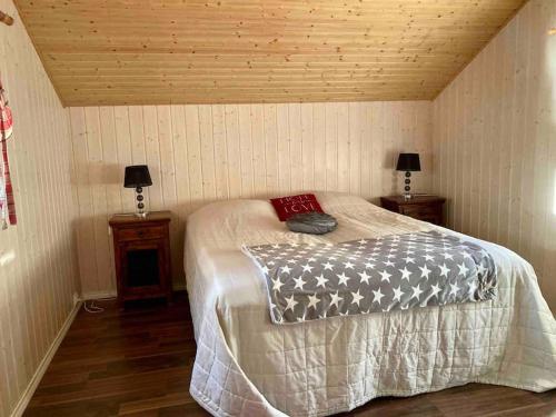 ein Schlafzimmer mit einem Bett und zwei Nachttischen in der Unterkunft Villa Hyppykallio, LaatuLomat in Juva