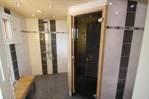 a bathroom with a walk in shower and a door at Villa Hyppykallio, LaatuLomat in Juva