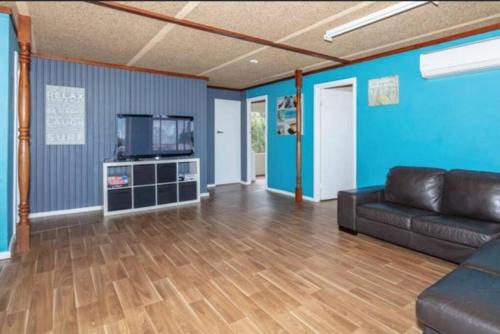 a living room with a couch and a tv at Cervantes Beach Shack in Cervantes