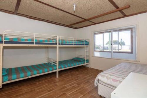 a room with two bunk beds and a window at Cervantes Beach Shack in Cervantes