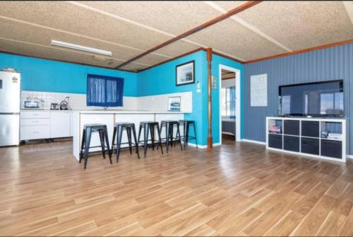 a kitchen with blue walls and a table and chairs at Cervantes Beach Shack in Cervantes