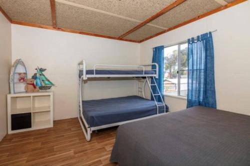 ein Schlafzimmer mit einem Etagenbett und einem Fenster in der Unterkunft Cervantes Beach Shack in Cervantes