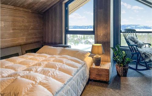 a bedroom with a large bed in a room with windows at Awesome Home In Rauland With Sauna in Rauland