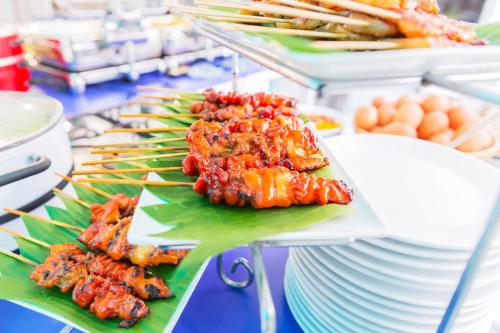 a buffet with plates of food on a table at Hotel Zing in Pattaya South