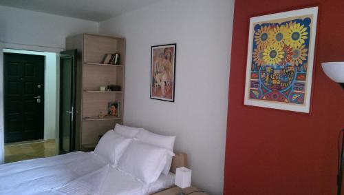 una camera da letto con un letto bianco e un quadro sul muro di Apartment Kapishtec a Skopje