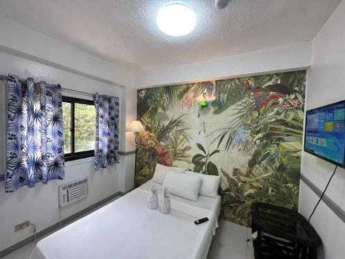 Habitación con sofá blanco y mural de plantas en Generosa Beach Club, en Bauang