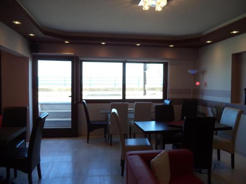 a dining room with tables and chairs and a window at Antonios Rooms in Akrata