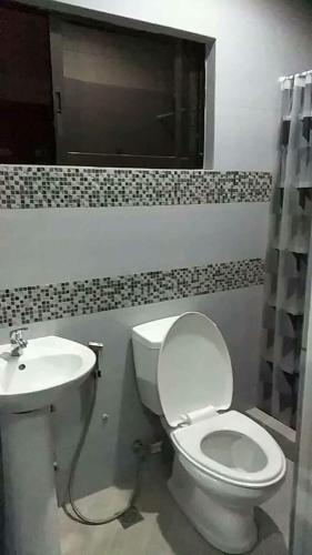 a bathroom with a toilet and a sink at Peach Haven in Cebu City