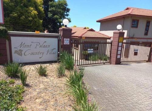 a fence with a sign in front of a house at Just Bed & bath by mama R in Newcastle