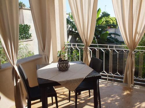 a table with chairs and a vase on a balcony at Villa Lazzari B&B Tra i due Mari in Maglie