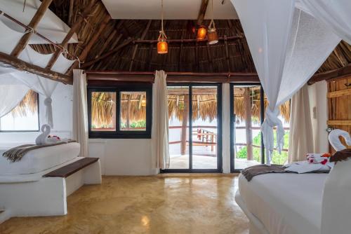 a bedroom with two beds and sliding glass doors at Casa Aakbal - Luxury Beach Front Villa in Tulum