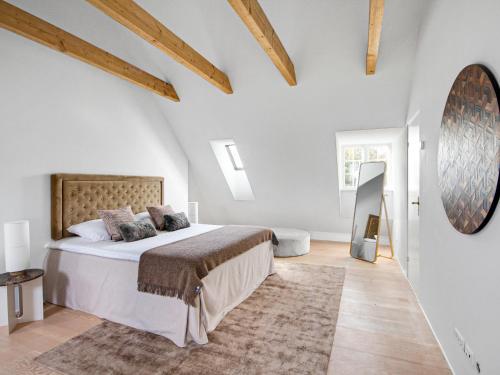 a bedroom with a bed in a room with wooden ceilings at Sanders Rosenlund - Luxury North of Copenhagen in Vedbæk