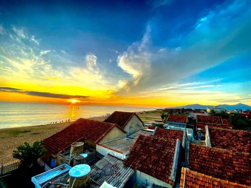 a view of the beach and buildings at sunset at NGÀI Villa in Phu Yen