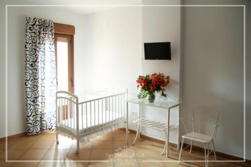 a room with a crib and a table and a television at Casa Rural Doña Blanca in Santa Cruz de la Sierra