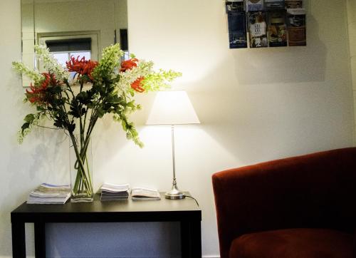 a vase of flowers on a table next to a lamp at Mildura Riverview Motel in Gol Gol